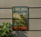 A vintage-style metal sign for Cape May Bird Observatory in New Jersey, featuring a colorful illustration of a bird and a lighthouse.