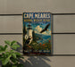 A vintage metal sign for Cape Meares National Wildlife Refuge in Oregon, featuring a lighthouse, puffins, and a bird in flight.