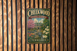 A vintage-style metal sign for Cheekwood Estate & Gardens in Tennessee, featuring a house surrounded by flowers and a pond.