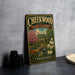A vintage-style metal sign for Cheekwood Estate & Gardens in Tennessee, featuring a colorful illustration of a house surrounded by flowers and a garden.