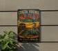 A vintage-style metal sign for the Coastal Virginia Wildlife Observation, featuring an illustration of a bird and a wooden structure, mounted on a wall.