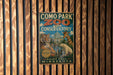 A vintage-style metal sign for Como Park Zoo and Conservatory, featuring illustrations of various animals and a building.