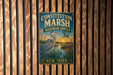 A vintage metal sign for the Constitution Marsh Audubon Center in New York, featuring an illustration of a heron and a sunset.