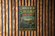 A vintage-style metal sign for Corkcrew Swamp Sanctuary in Audubon, Florida, featuring an illustration of a bird and a swamp landscape.