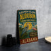 A vintage-style metal sign for Dauphin Island Audubon Bird Sanctuary in Alabama, featuring illustrations of birds and nature.