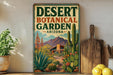 a vintage-style sign for the Desert Botanical Garden in Arizona, with a desert landscape and various desert plants and cacti depicted on the sign.