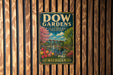 A vintage metal sign for Dow Gardens in Michigan, featuring a colorful illustration of a garden with flowers, trees, and a bridge.