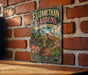 A vintage-style sign for Elizabethan Gardens in North Carolina, featuring a garden scene with a brick wall and a wooden bench in the foreground.
