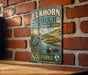 A vintage-style metal sign for the Elkhorn Slough National Estuarine Reserve in California, featuring an illustration of a heron and an otter in the water.