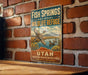A vintage-style sign for Fish Springs National Wildlife Refuge in Utah, featuring a scenic illustration of ducks swimming in a lake surrounded by mountains.