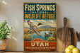 A vintage-style sign for Fish Springs National Wildlife Refuge in Utah, featuring a duck in flight over a lake surrounded by mountains.