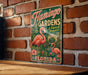 A vintage-style metal sign for Flamingo Gardens in Florida, featuring a pink flamingo and tropical foliage.