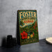 A vintage-style metal sign for Foster Botanical Garden in Hawaii, featuring a tropical landscape with palm trees, flowers, and a waterfall.