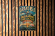A vintage metal sign for the Grand Isle Migratory Bird Sanctuary in Louisiana, featuring a bird illustration and text.