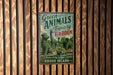A vintage-style metal sign with the text "Green Animals Topiary Garden" and "A Unique Living Sculpture Garden Rhode Island" is displayed on a wooden fence.