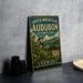 A vintage-style sign for the Green Mountain Audubon Center in Vermont, featuring a colorful illustration of a bird and a scenic landscape.