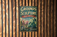 A vintage metal sign with the text "Grounds for Sculpture New Jersey" and an illustration of a sculpture, mounted on a wooden wall.