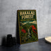 A vintage-style metal sign for the Hakalau Forest National Wildlife Refuge in Hawaii, featuring an illustration of a bird and lush greenery.