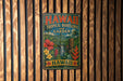 A vintage metal sign with the text "HAWAII TROPICAL BIOSERVE AND GARDEN" is displayed on a wooden wall.