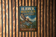 A vintage-style metal sign for the Hawk Mountain Sanctuary in Pennsylvania, featuring an illustration of a hawk in flight.