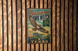 A vintage-style metal sign with a hawk illustration and text, hanging on a wooden wall.