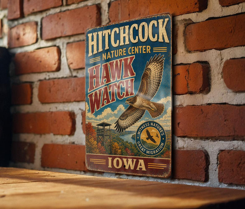 A vintage metal sign for the Hitchcock Nature Center in Iowa, featuring an illustration of a hawk and the text "Hitchcock Nature Center" and "Hawk Watch".