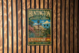 A vintage metal sign for Huntington Library and Botanical Gardens in California, featuring an illustration of a building surrounded by lush greenery and palm trees.