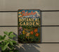 A vintage-style metal sign for Idaho Botanical Garden, featuring a colorful illustration of flowers and plants.