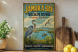 A vintage-style poster advertising Jamaica Bay Wildlife Refuge in New York, featuring a large blue heron and ducks in a grassy field with a city skyline in the background.
