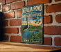 A vintage-style metal sign for the Kealia Pond National Wildlife Refuge in Hawaii, featuring a bird and a tropical landscape.