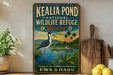 A vintage-style metal sign for the Kealia Pond National Wildlife Refuge in Hawaii, featuring an illustration of a bird and a tropical landscape.