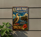A vintage-style metal sign for the Kilauea Point National Wildlife Refuge in Hawaii, featuring a bird and a lighthouse on a cliff overlooking the ocean.