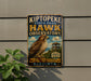 a metal sign with a bird illustration, mounted on a wall next to a plant.