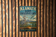 A vintage-style metal sign for Klath Bird Observatory, featuring a large blue bird and text promoting wildlife conservation and education.