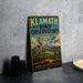 A vintage-style sign for Klamath Bird Observatory, featuring a blue background with a large bird illustration and text promoting wildlife, education, conservation, and discovery.