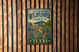 A metal sign with the text "LADY BIRD JOHNSON WILDFLOWER CENTER TEXAS" hanging on a wooden fence.
