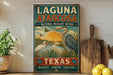 A vintage-style sign for the Laguna Atascosa National Wildlife Refuge in Texas, featuring illustrations of birds and a sunset landscape.