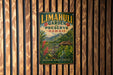 A vintage metal sign with a tropical landscape and text, mounted on a wooden wall.