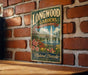A vintage-style metal sign for Longwood Gardens in Pennsylvania, featuring a scenic illustration of the garden with a fountain and flowers.