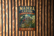 A vintage metal sign for Madera Canyon, Arizona, featuring a bird and a mountain landscape.