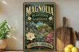 A vintage-style sign for Magnolia Plantation and Gardens in South Carolina, featuring a lush garden scene with a large white magnolia flower and a house in the background.