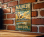A vintage-style metal sign for Malheur National Wildlife Refuge in Oregon, featuring an illustration of a bird in flight over a scenic landscape.