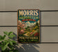 A vintage metal sign for Morris Arborum, a Pennsylvania nursery, is displayed on a wall next to a plant.