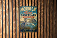 A vintage-style metal sign for Morro Bay Bird Sanctuary in California, featuring a large bird and a scenic landscape.