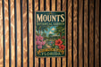 A vintage-style metal sign for the Mounds Botanical Garden in West Palm Beach, Florida, featuring a tropical landscape with palm trees, flowers, and a building.
