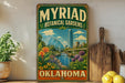 A vintage-style metal sign for the Myriad Botanical Gardens in Oklahoma, featuring a cityscape and lush greenery.