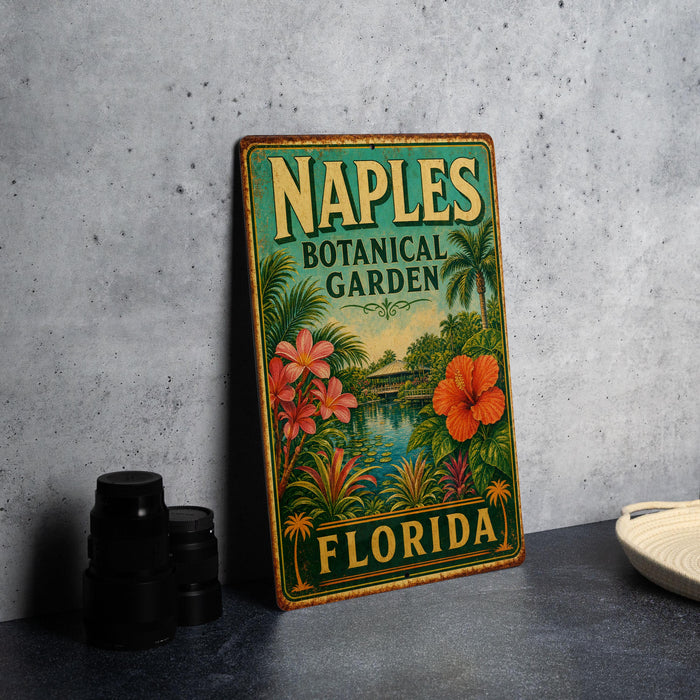 A vintage-style metal sign for the Naples Botanical Garden in Florida, featuring colorful illustrations of tropical plants and flowers.