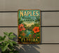 A vintage-style metal sign for the Naples Botanical Garden in Florida, featuring colorful tropical flowers and plants.