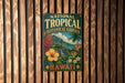 A vintage-style metal sign for the National Tropical Botanical Garden in Hawaii, featuring tropical flowers and lush greenery.