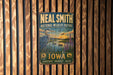 A vintage-style metal sign for the National Wildlife Refuge in Iowa, featuring an illustration of a bird and a lake with a sunset in the background.